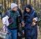 A refugee worker (left) accompanies a Syrian family in the woods near Kliszkeli.  Back to the right: An employee of the Polish border guard