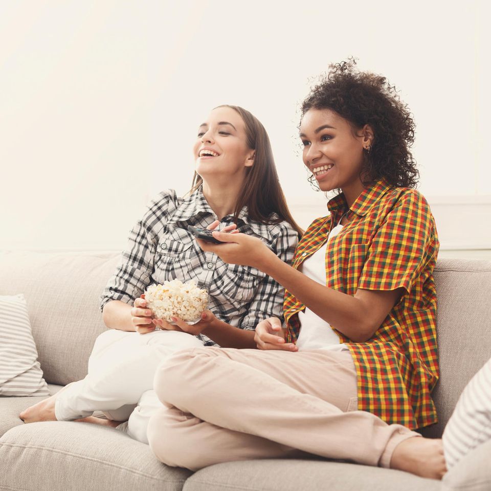 What does your favorite series reveal about your personality: two women laughing while watching TV.