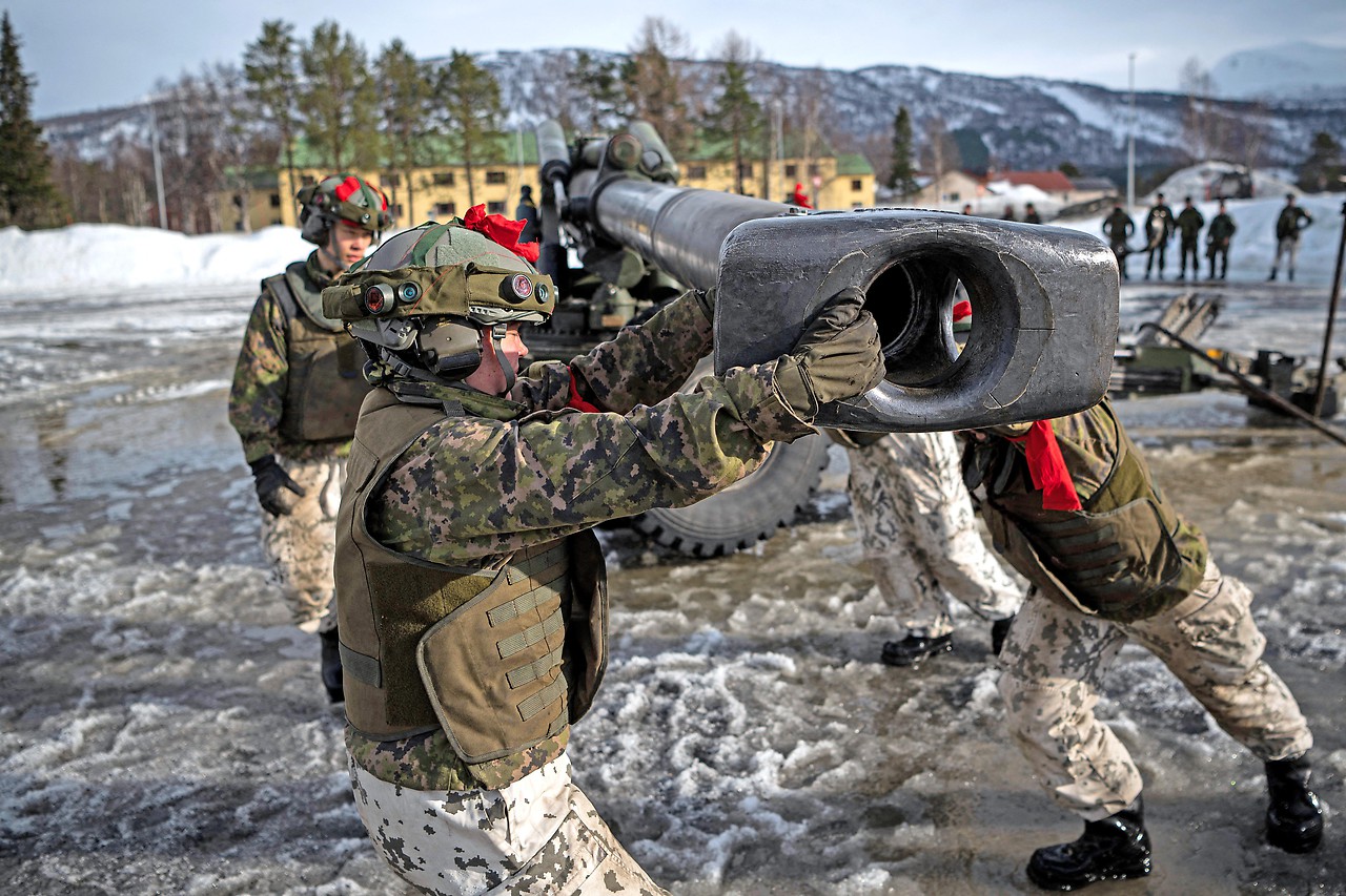 Finnish soldiers spin a pistol during a military exercise Cold Response 22