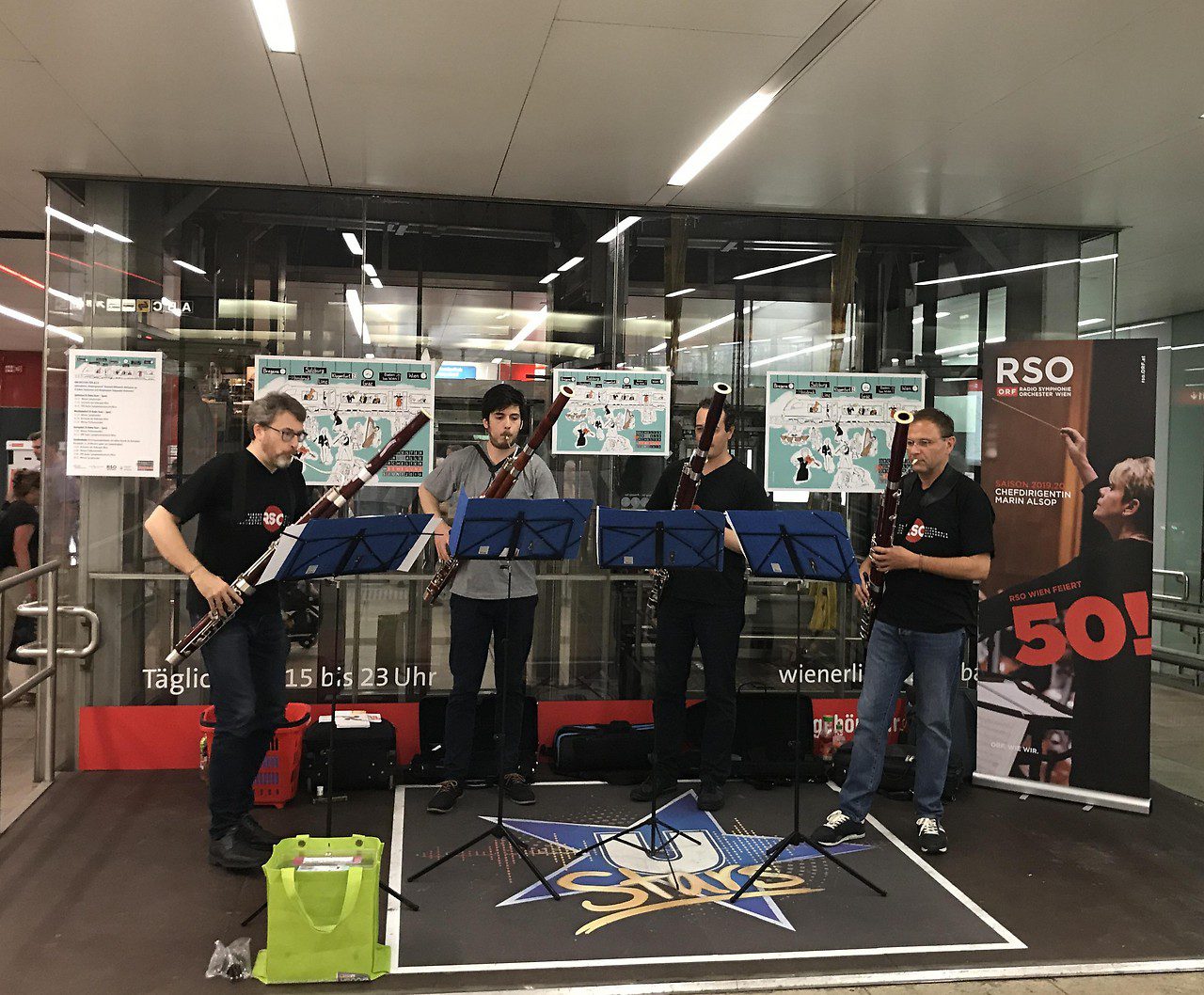 A four-piece radio symphony orchestra performs at a subway station