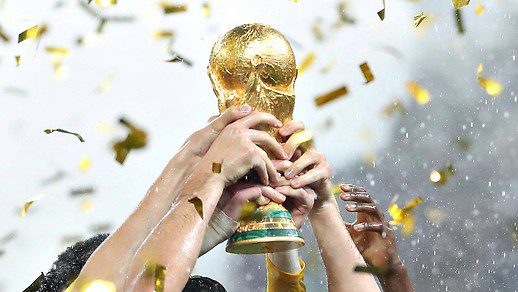 Hands holding the World Cup in a rain of confetti